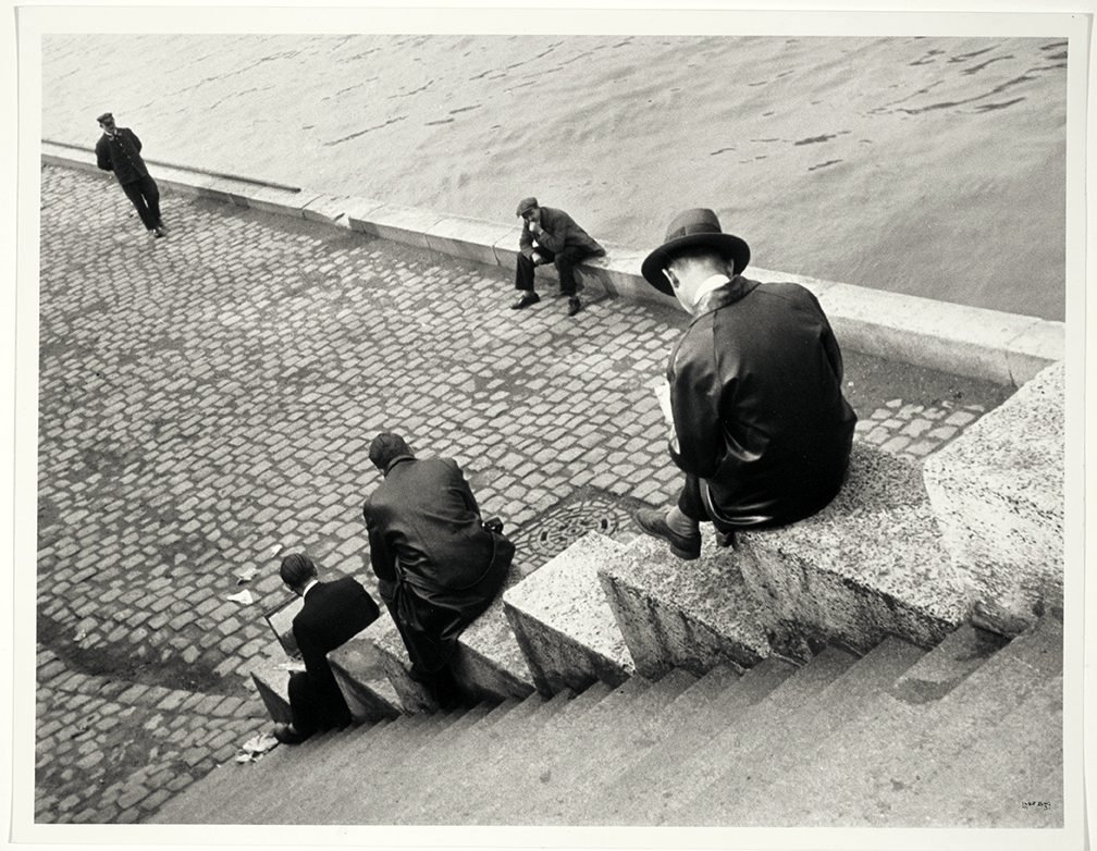 Tres hombres sentados en las escaleras junto al Sena